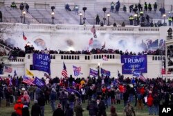 Pristalice Trumpa upadaju u zgradu Kongresa 6. januara 2021. (Foto: AP/John Minchillo)