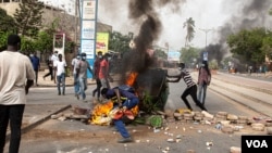 Protesters throw a dumpster on a fire in Dakar, Senegal Friday, June 17, 2022. (Annika Hammerschlag/VOA)