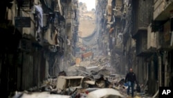 FILE - Residents walk through the destruction of the once rebel-held Salaheddine neighborhood in the eastern Aleppo, Syria, Jan. 20, 2017. 