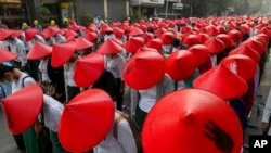 FILE - In this March 3, 2021, photo, anti-coup school teachers in their uniform and traditional Myanmar-hats participate in a demonstration in Mandalay, Myanmar. 