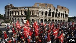 Para demonstran Italia melewati monumen 'Colosseum' di Roma saat pemogokan umum para pekerja di Italia (6/9).