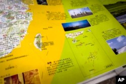 Peta baru China menunjukkan Laut China Selatan dengan klaim sembilan garis putus-putus di dalam wilayah China dan garis baru di sebelah Taiwan terlihat di peta, di sebuah toko buku di Beijing, Jumat, 1 September 2023. (Foto: AP)
