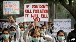 Para siswa mengacungkan poster-poster berisi slogan-slogan memprotes mengenai tingkat polusi di New Delhi, India, 15 November 2017.