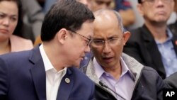 Former chief of the Philippine National Police Criminal Investigation and Detection Group (PNP-CIDG) and now Mayor Benjamin Magalong, right, talks to Justice Secretary Menardo Guevarra at the resumption of the Senate probe on the release of hundreds…