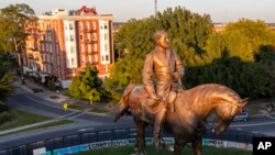 The statue of Confederate Gen. Robert E. Lee is bathed in the late sun on Monument Avenue in Richmond, Va., Sept. 6, 2021. 