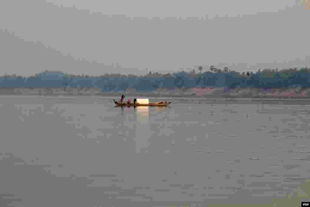 A man paddling a boat across Mekong River in Chhloung District, Kratie Provice, Cambodia, March 16, 2014. (Nov Povleakhena/VOA Khmer)