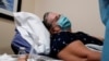 Seorang pasien bernama Cathy Hardin tampak berbaring di ranjang di rumah sakit Sarasota Memorial Urgent Care Center di Sarasota, Florida, pada 23 September 2021. Cathy positif terjangkit virus corona di tengah merebaknya varian Delta di AS. (Foto: Reuters/Shannon Stapleton)