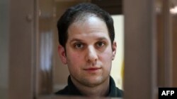FILE - Jurnalis AS Evan Gershkovich, ditangkap atas tuduhan spionase, melihat keluar dari dalam kurungan terdakwa sebelum sidang untuk mempertimbangkan banding atas perpanjangan penahanan pra-sidang, di Pengadilan Kota Moskow, Rusia, 20 Februari 2024.