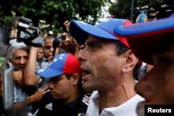 FILE - Venezuela opposition leader Henrique Capriles confronts security forces at an anti-government rally in Caracas, Venezuela, May 12, 2017.