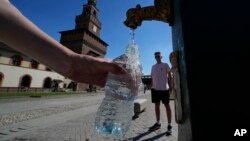 Turista puni vodu kod česme u Milanu, u Italiji, 25. juna 2022. (Foto: AP/Luca Bruno)
