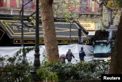 Orang-orang berjalan di depan Bataclan Cafe dan gedung yang tersambung dengan cafe tersebut sehari setelah sejumlah serangan mematikan di Paris, 14 November 2015.