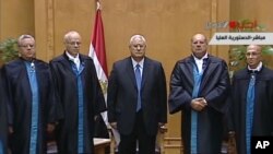 Adly Mansour (tengah) dilantik menjadi Presiden sementara Mesir, di Mahkamah Konstitusional Mesir di Kairo (4/7).