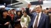 Cambodia's self-exiled opposition party founder Sam Rainsy, who has vowed to return to his home country, gestures to supporters after being prevented from checking-in for a flight from Paris to Bangkok at Roissy Airport in Paris, France Nov. 7, 2019.