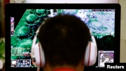Seorang laki-laki bermain game komputer di sebuah warung Internet di Beijing, China.