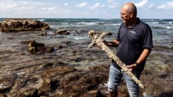 Yaakov Sharvit dari Otoritas Kepurbakalaan Israel memegang pedang yang dipercaya merupakan milik dari tentara Perang Salib, di Caesarea, Israel, pada 18 Oktober 2021. (Foto: Reuters/Ronen Zvulun)
