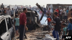 FILE - Palestinians gather at the site of an Israeli strike on a camp for internally displaced people in Rafah on May 27, 2024. (Photo by Eyad BABA / AFP)