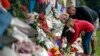 Mourners lay flowers on a wall at the Botanical Gardens in Christchurch, New Zealand, March 16, 2019. New Zealand's stricken residents reached out to Muslims in their neighborhoods and around the country Saturday, in a fierce determination to show kindness to a community in pain.