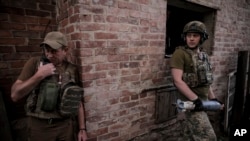 In this photo provided by the 24th Mechanized brigade press service, Ukrainian soldiers prepare to fire 120mm mortar towards Russian position on the front line at an undisclosed location in Ukraine's Donetsk region, June 4, 2024.