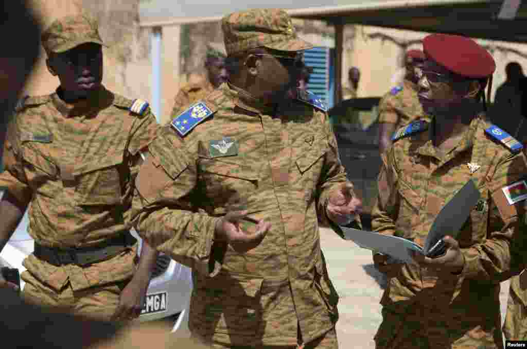 Burkina Faso's military chief General Honore Traore, center, speaks with fellow officers before a news conference announcing his takeover of power, at army headquarters in Ouagadougou, Burkina Faso, Oct. 31, 2014.