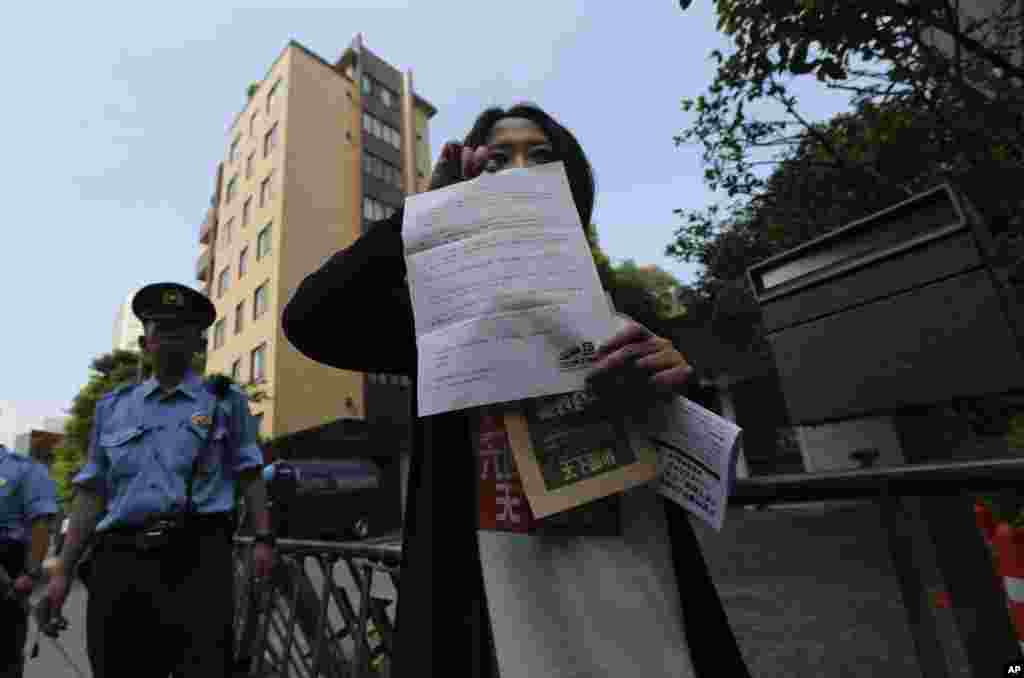 Seorang demonstran menunjukkan surat protes sebelum memasukkannya ke dalam kotak surat di Kantor Kedutaan Besar China&nbsp; di Tokyo, Jepang (4/6).