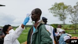 Petugas medis memeriksa suhu tubuh warga di Gatumba di tengah pandemi Covid-19 di Burundi (foto: ilustrasi). 