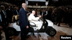 Pope Francis is driven on a golf cart as he arrives at Madison Square Garden to celebrate mass in New York, Sept. 25, 2015. 