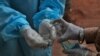 Seorang petugas kesehatan tampak membersihkan tangannya setelah mengambil sampel tes usap (swab test) dari seorang pasien di pusat tes COVID-19 di Hyderabad, India, pada 11 Oktober 2020. (Foto: AP/Mahesh Kumar A.)