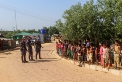Petugas keamanan (kiri) memberikan pengarahan dengan menggunakan pengeras suara untuk meningkatkan kewaspadaan di tengah pandemi Covid-19 di kamp pengungsi Rohingnya di Ukhia, 15 Mei 2020.