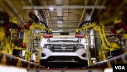 FILE - More automation at factories across the globe means fewer people on the production line.