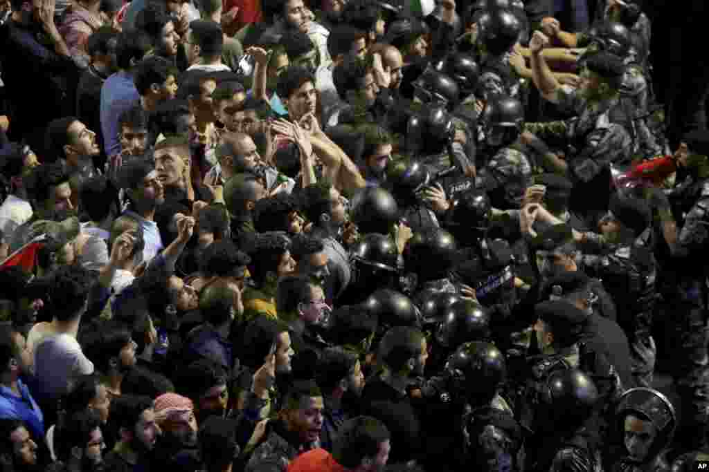 Jordanian riot police and security forces scuffle with protesters during a demonstration outside the Prime Minister&#39;s office in Amman.