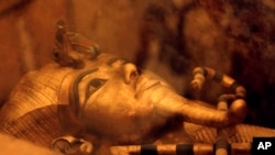 FILE - One of Egypt's famed King Tutankhamun's golden sarcophagus is displayed at his tomb in a glass case at the Valley of the Kings in Luxor, Egypt, April 1, 2016.