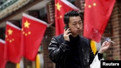Seorang pria tengah merokok sambil berjalan melintasi sebuah restoran di Beijing (Foto: dok).