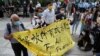 Aktivis pro-demokrasi Figo Chan, Avery Ng dan lainnya memegang spanduk di depan media sebelum persidangan atas dakwaan terkait sidang tidak sah pada 1 Oktober 2019, di luar pengadilan di Hong Kong, China, 17 Mei 2021. (Foto : REUTERS/Lam Yik)