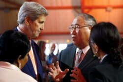 Menlu AS saat itu John Kerry (kiri) berbicara dengan pejabat urusan iklim China di Le Bourget 12 Desember 2015.