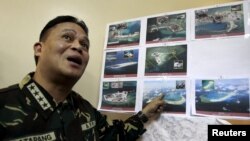 Armed Forces of the Philippines (AFP) Chief of Staff Gregorio Pio Catapang shows some images of the structures being built by China at the disputed islands during a news conference at the AFP headquarters in Manila, April 20, 2015.