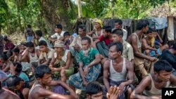 FILE - Rohingya Muslims from Myanmar wait to carry food items from Bangladesh's border toward a no man's land where they set up refugee camps in Tombru, Bangladesh, Sept. 15, 2017.