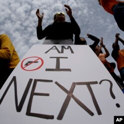 High school sophomore Dakotah Brown, 16, holds a sign at a rally for tighter gun laws, April 20, 2018 in Kansas City, Mo.