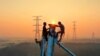 Employees work on a high voltage transmission tower in Yichun, in China's central Jiangxi province, Sept. 28, 2021.