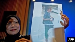 Polisi Malaysia menunjukkan foto pemuda Iran berusia 19 tahun, Pouria Nour Mohammad Mehrdad, salah satu dari dua pria penumpang Malaysia Airlines penerbangan MH370 yang menggunakan paspor curian. (AFP/Manan Vatsyayana)