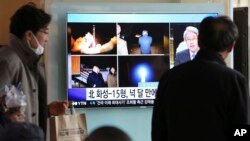 People watch a TV screen showing a local news program reporting about North Korea's missile launch, at the Seoul Railway Station in Seoul, South Korea, Nov. 30, 2017.