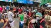 People stand in lines to get COVID-19 tests in Samut Sakhon, South of Bangkok, Thailand, Sunday, Dec. 20, 2020. Thailand reported more than 500 new coronavirus cases on Saturday. (AP Photo/Jerry Harmer)