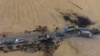 An areal picture taken on Oct. 28, 2019, shows vehicles near a destroyed truck at the spot where Abu Hassan al-Muhajir, the Islamic State (IS) group's spokesman, was reportedly killed in a raid in the Syrian village of Ayn al-Bayda near Jarablus.
