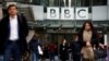 FILE - Pedestrians walk past a BBC logo at Broadcasting House in London, Britain, Jan. 29, 2020. 
