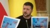 Президент Украины Владимир Зеленский демонстрирует фотографии находящегося в заключении экс-президента Грузии Михаила Саакашвили (архивное фото) 
