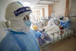 Medical workers in protective suits attend to a patient inside an isolated ward of Wuhan Red Cross Hospital in Wuhan, Hubei province, China Feb. 16, 2020.