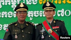 រូបឯកសារ៖ លោក​នាយករដ្ឋមន្ត្រី ហ៊ុន សែន (ឆ្វេង) ថតរូប​ជាមួយ​នឹង​កូន​ប្រុស​ច្បង​របស់​លោក​ គឺ​លោក ហ៊ុន ម៉ាណែត​ នៅ​ជាយ​រាជធានី​ភ្នំពេញ ថ្ងៃទី១៣ ខែតុលា ឆ្នាំ២០០៩។ (REUTERS/Chor Sokunthea/File Photo)