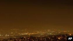 Smoke from a wildfire north of the Greek capital, spreads over Athens, Greece, Aug. 3, 2021. Thousands of people fled their homes north of Athens on Tuesday as a wildfire broke out of the forest and reached residential areas.