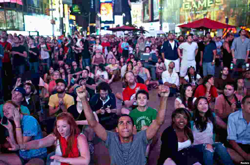 Warga New York di Times Square ikut merayakan berita keberhasilan Curiosity mendarat di Mars lewat siaran langsung oleh Pusat Pengendalian Misi NASA ke layar lebar di Times Square, New York (6 Agustus 2012). 