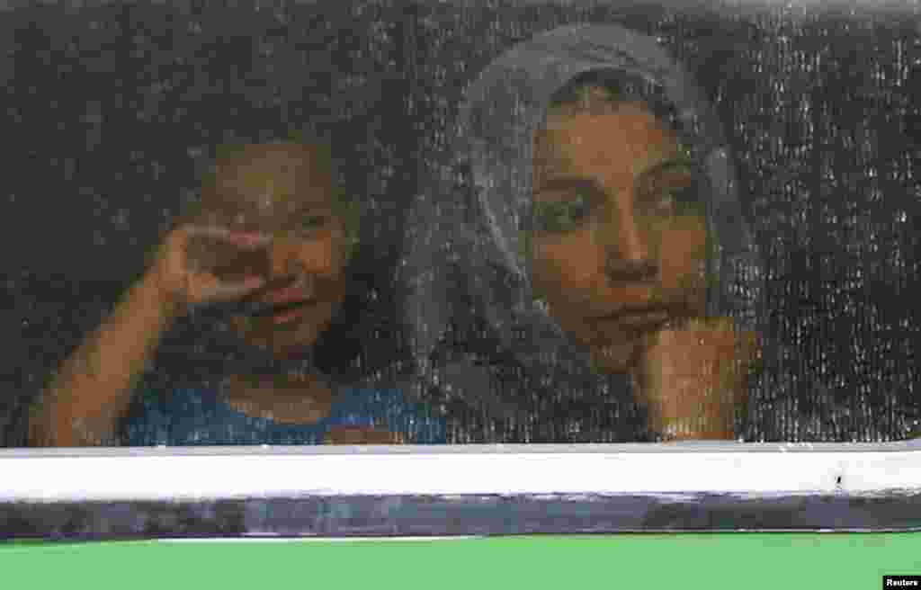 Migrants look out through the window of a train at the railway station in Bicske, Hungary, Sept. 4, 2015. 