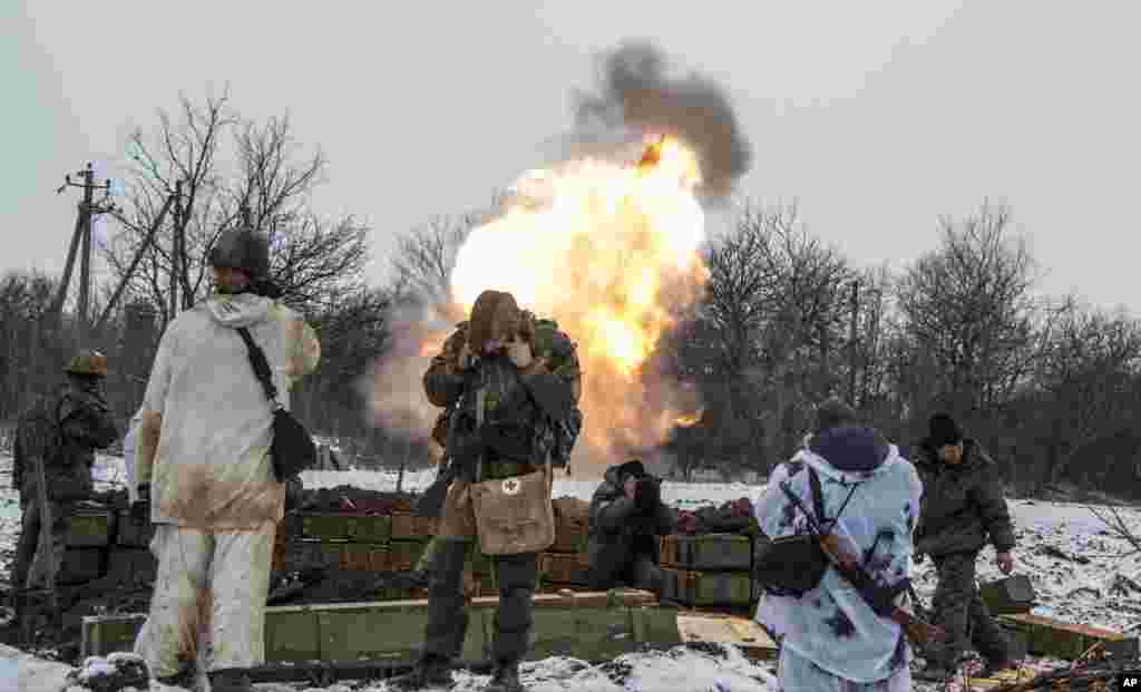 Russian-backed separatists cover their ears as they fire a mortar towards Ukrainian troops outside the village of Sanzharivka, northeast of Debaltseve, eastern Ukraine, Feb. 11, 2105.